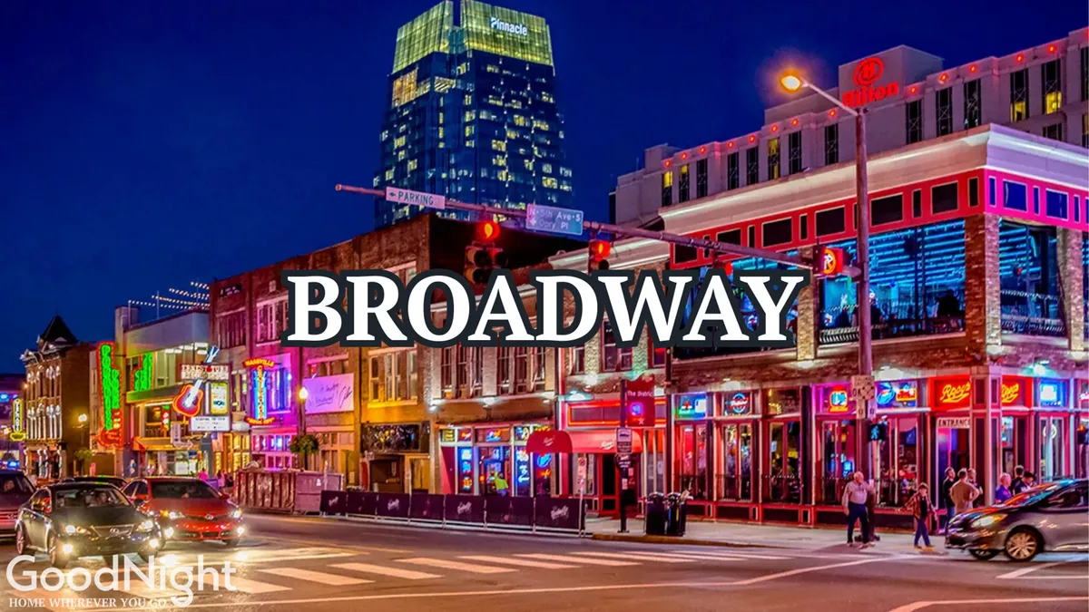 A vibrant, neon-lit street scene featuring busy sidewalks, buildings aglow with colorful lights, and people out enjoying dining, shopping, and live music. The energetic atmosphere is unmistakably Nashville at night.