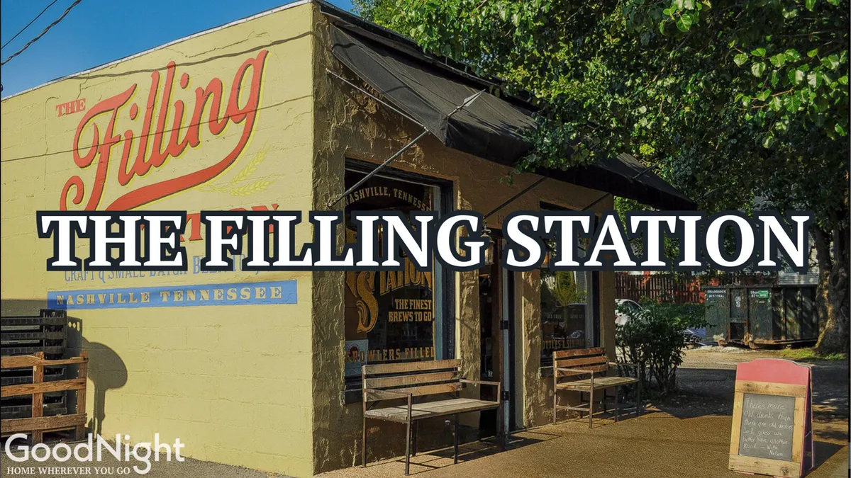 An inviting exterior with The Filling Station sign, outdoor seating, and a colorful mural visible in the background. The patio is set up for casual dining and socializing, suggesting a hip, communal vibe.